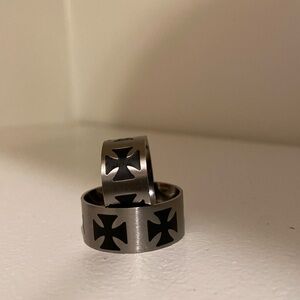 Two matching stainless steel rings with maltese cross design.